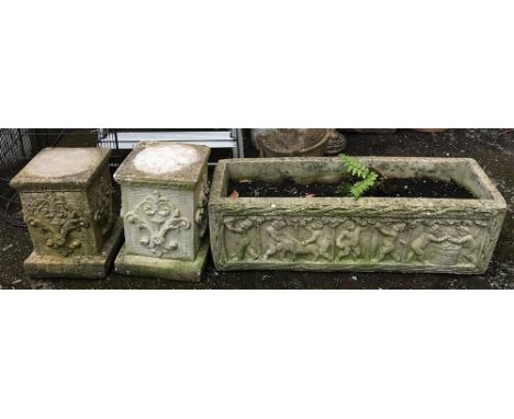 A pair of composite stone plinths, each 32cmH, together with a trough planter depicting cherubs, 79cmL 