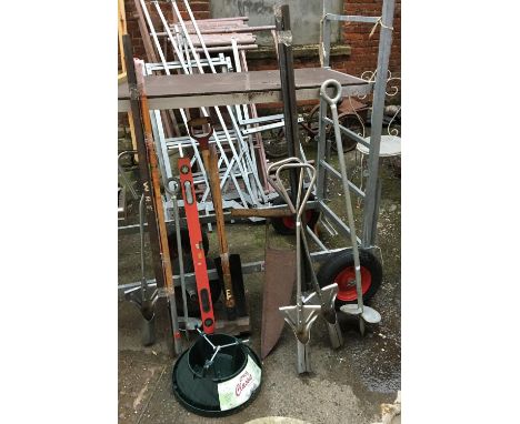 A mixed lot of tools to include sledge hammer, augers, shovel, level, iron bars, Christmas tree stand, etc 