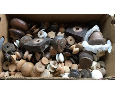 A box of various turned wooden and ceramic knobs 