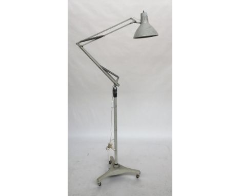 A floorstanding anglepoise lamp marked Luxo, Norway, on a three wheeled heavy base with three casters 