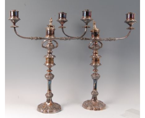 A pair of silver plated three light candelabra, in the Rococo taste, circa 1900, each having twin outswept arms and on multi-