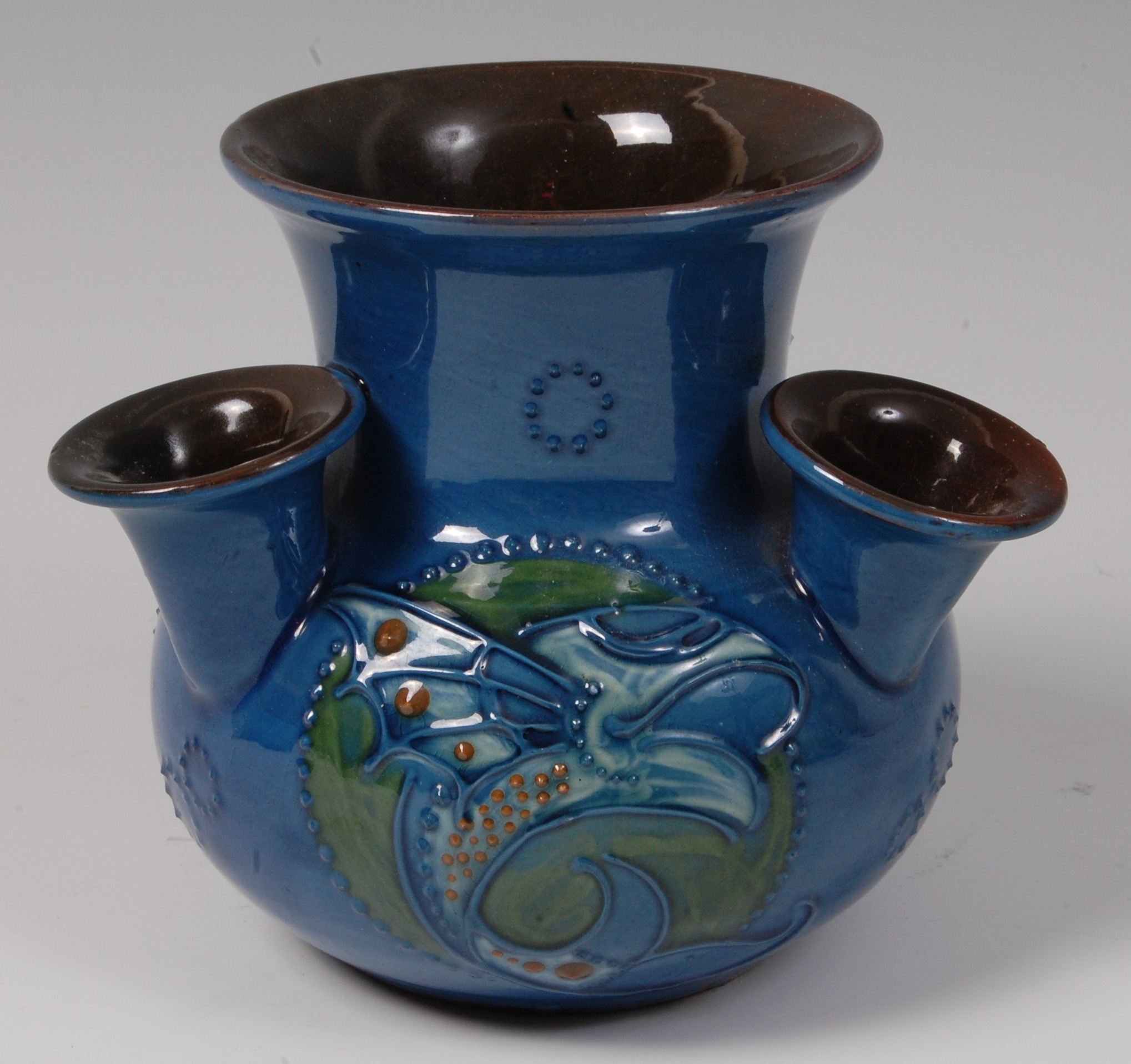 A Charles Brannam Devon Pottery four-stem udder vase, on blue ground ...