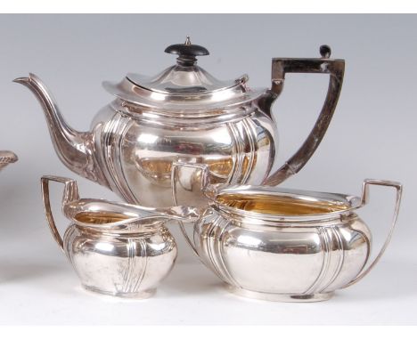An Edwardian silver three piece tea-set, comprising teapot, twin handled sugar and cream jug, each with gilt washed interior,