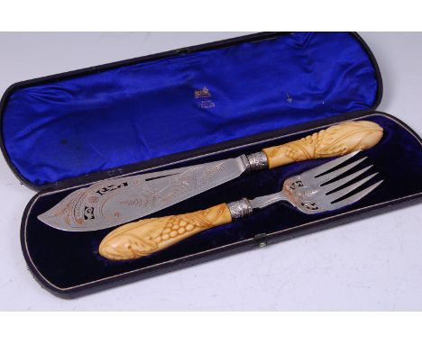 A pair of Victorian silver fish servers, the blade and fork each with pierced and etched decoration, the ivory handles carved
