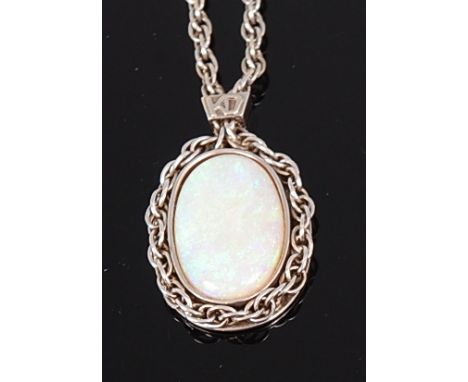 A 9ct white gold and opal set pendant, the cabochon doublet opal measuring approx 23 x 14mm, in a white gold chainlink surrou