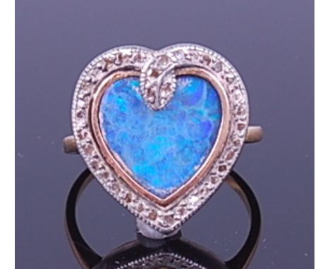 A vintage 18ct gold, opal and diamond dress ring, arranged as a heart shaped opal doublet within a pavé set small rough cut d