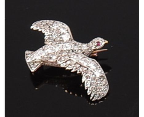 A yellow metal diamond set bird brooch, the whole pavé set with graduated old cut diamonds and having small cabochon ruby eye