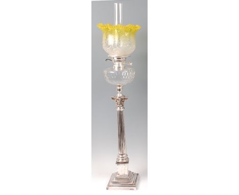 A silver plated Corinthian column pedestal oil lamp, having yellow tinted and acid etched handkerchief glass shade and thumb-