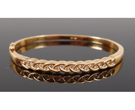 An 18ct gold and diamond set Celtic influenced bangle, pavé set with twenty brilliant cut diamonds, total diamond weight esti