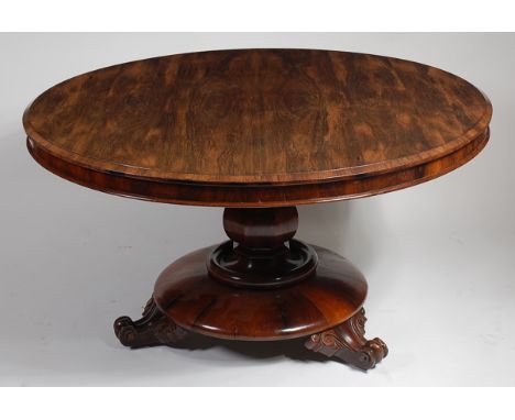 A William IV rosewood breakfast table, the circular tilt-top on octagonal baluster column to platform base and scroll feet, d