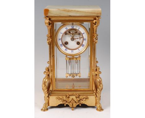 A circa 1900 French gilt bronze four glass mantel clock, having an onyx top, the corners with fruiting and scrolling bracket 