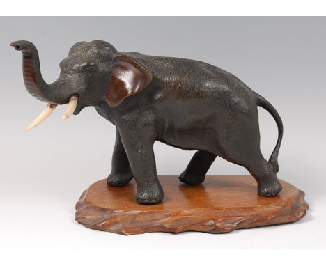 A Japanese Meiji period bronze elephant, naturalistically modelled with raised trunk, having ivory tusks, unsigned, h.18cm, o