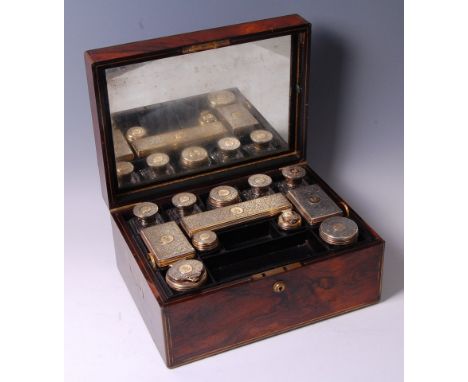 A Victorian rosewood and brass bound travelling toiletry box, the hinged lid opening to reveal mirrored interior with green l