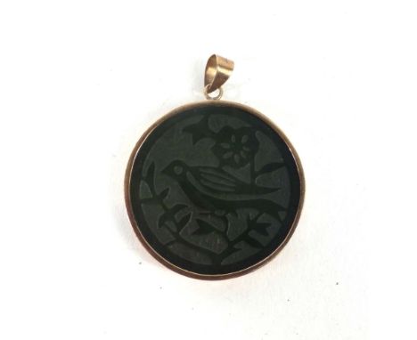 A 14ct yellow metal mounted circular jade pendant carved with a bird seated on a blossoming branch, d. 3.1 cm