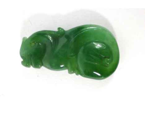 A small carved jade pendant in the form of a foo dog, l. 4.3 cm