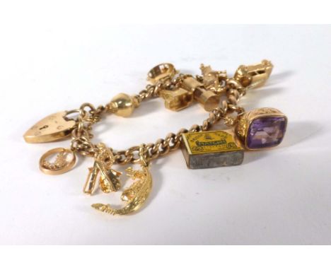A 9ct yellow gold curblink bracelet with heart shaped padlock clasp suspending thirteen gold and yellow metal charms includin
