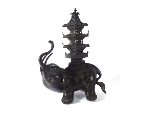 A Chinese bronzed lantern/censer modelled as a caparisoned elephant, it's trunk raised and supporting a lantern in the form o