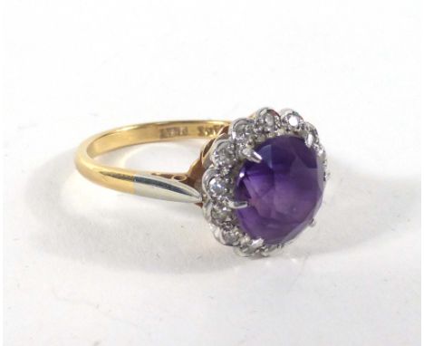 An 18ct yellow gold and platinum highlighted ring set circular amethyst in a surround of small diamonds,ring size O,3.8 gms