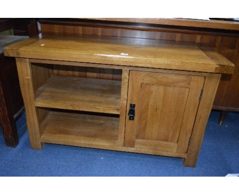 A LIGHT OAK TV STAND, with a single door (matching previous lot)