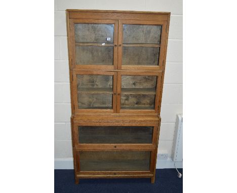 A LIGHT OAK GLAZED FOUR TIER SECTIONAL BOOKCASE, top, two sections with double glazed doors above two sections with fall fron