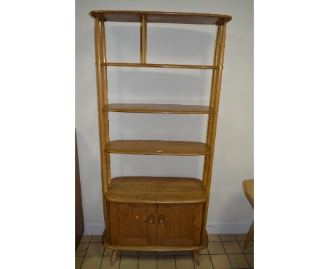 AN ERCOL BLONDE ELM ROOM DIVIDER/SHELVES, the two central shelves being adjustable above a cupboard base, approximate size wi