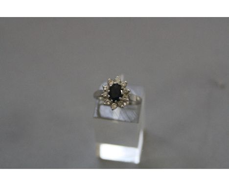 A MODERN PLATINIUM SAPPHIRE AND DIAMOND OVAL CLUSTER RING, one oval mixed cut blue sapphire measuring approximately 7mm x 5mm