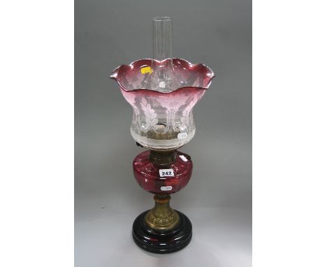 AN OIL LAMP, with cranberry glass reservoir and glass shade