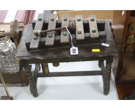 AN OAK TABLE TOP XYLOPHONE, circa 1930, on bobbin turned legs with centre stretcher, width approximately 34cm