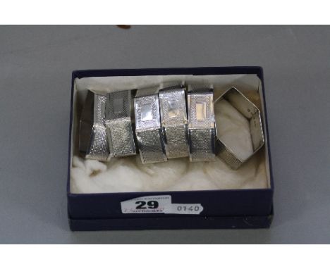 A SET OF SIX GEORGE V SILVER LOZENGE SHAPED NAPKIN RINGS, engine turned decoration, blind rectangular cartouche, maker F.H.Ad