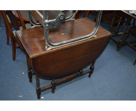 AN OAK BARLEY TWIST GATE LEG TABLE