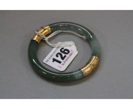 A MODERN JADE BANGLE, round in shape, hinged, measuring approximately 75mm in diameter, jade measuring approximately 8.8mm in