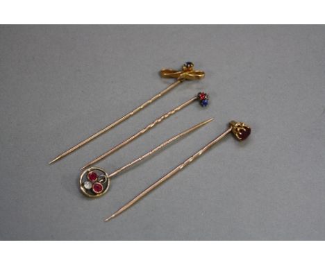 FOUR GOLD STICK PINS, three set with diamonds