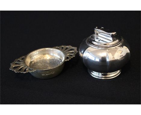 A silver Irish tea strainer , Dublin 1973 (2.6oz) and silver table lighter, Birmingham - outer case 2.9oz