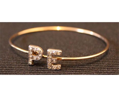 A Gold Bangle with initials PE in diamonte