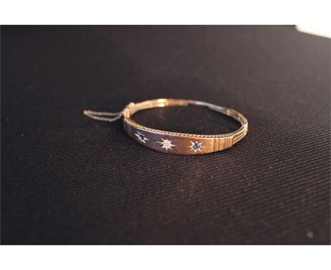 A 9ct Gold Bangle with a central diamond and 2 saphires with safety chain Total weight 10.66gms