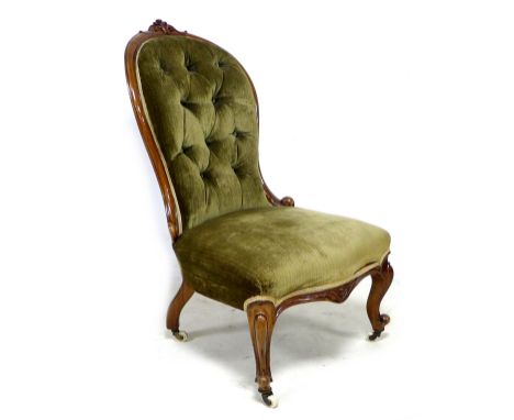 A Victorian button back nursing chair, with floral carved top-rail, upholstered in brown velvet, 59 by 65 by 100cm high. 