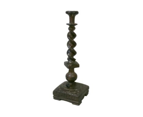 A carved oak candlestick, possibly 17th century, with circular drip tray set with a brass eight pointed star raised on a tape