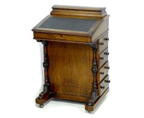 A Victorian walnut Davenport, with caddy shaped letter box to the top, a leather inset to its writing slope, a bank of four d