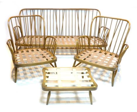 A group of dark Ercol furniture, comprising a three seater settee and two armchairs, a foot stool, together with an associate