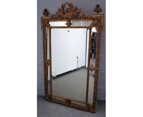 A 19th century French gilt framed marginal cushion mirror, with arrow quiver and flaming torch crest, 103cm wide x 173cm high