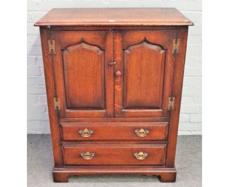 A small 17th century style oak side cupboard, by Titchmarsh &amp; Goodwin, the pair of arch panel doors over two drawers, on 