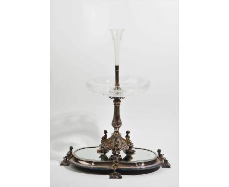 A silver plated metal mounted glass table centrepiece, the base with three seated putto, with foliate divisions at intervals,