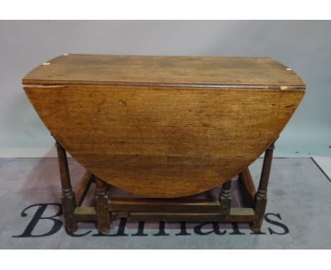 An 18th century oak oval gate leg dining table, on turned supports, 106cm wide x 72cm high.