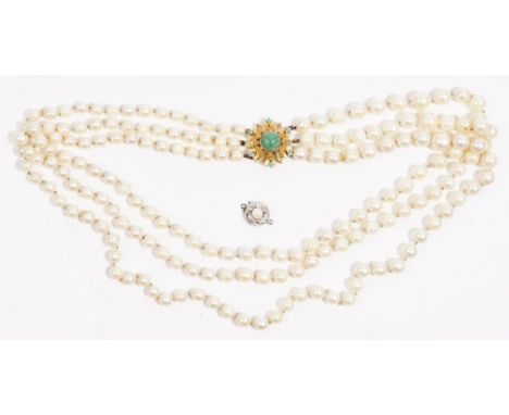 A three row necklace of graduated cultured pearls, on a gold and green gem set clasp, formed as a flowerhead, length includin
