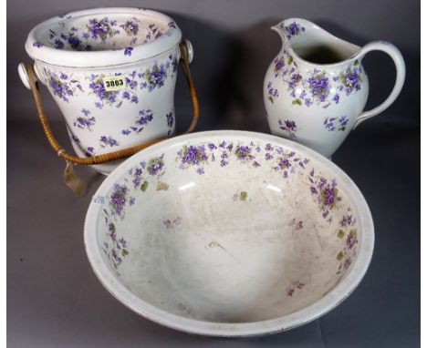 An early 20th century ceramic wash set comprising a jug and bowl and slop bucket, decorated with blue flowers, (3). 
