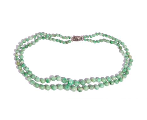 A two row necklace of jade beads, graduating in the size to the front, on a silver and marcasite clasp, detailed 925, gross w