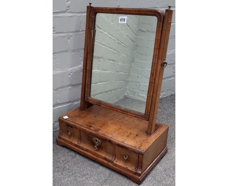 A George II figured and featherbanded walnut toilet mirror, with a three drawer base, on bracket feet, 41cm wide x 54cm high.