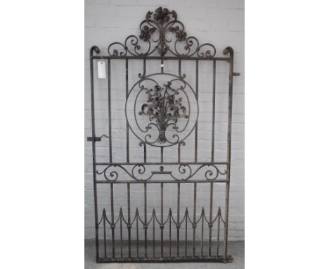 A wrought iron garden gate with arch crest and floral relief panel, 112cm wide including hinge, 199cm high. 