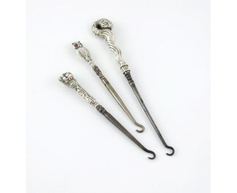 A novelty silver owl button hook, by Crisford and Norris, Birmingham 1908, textured feathers, set with red eyes, plus a butto