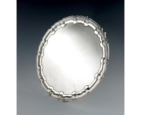 A silver salver, by William Hutton and Sons, Sheffield 1927, circular form, moulded border, on three gnarl feet, diameter 30.